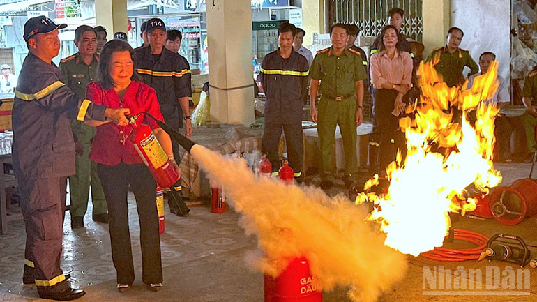 Hộ kinh doanh trên địa bàn xã Phước Long, tỉnh Cà Mau được cán bộ chuyên trách Công an tỉnh trực tiếp hướng dẫn sử dụng bình chữa cháy. ndo_br_anh-8-3592.jpg