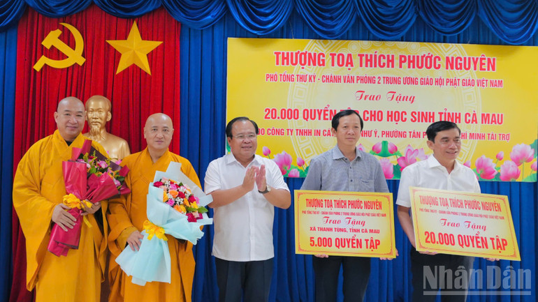 Đại diện Sở Giáo dục Cà Mau và xã Thanh Tùng tiếp nhận bảng tượng trưng tập hỗ trợ từ văn phòng 2 Trung ương Giáo hội Phật giáo Việt Nam. ndo_br_trao-tap-1-4857.jpg