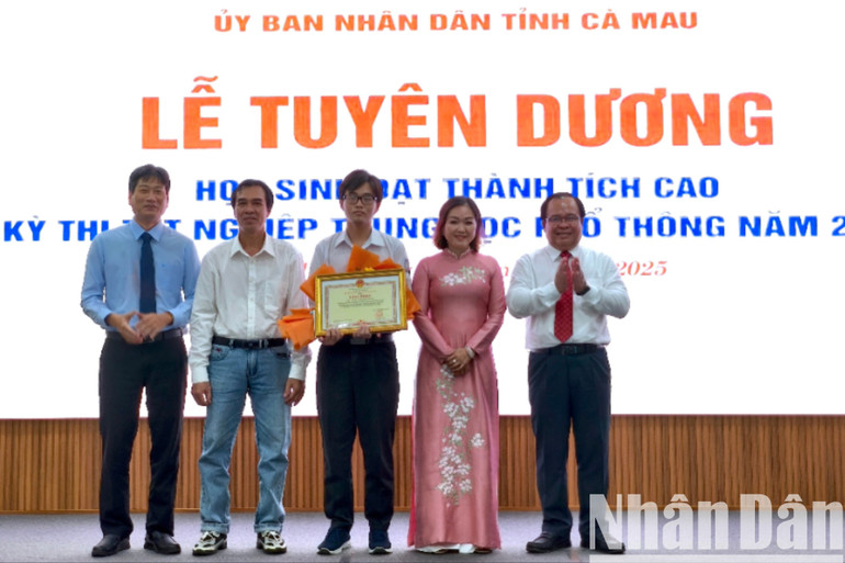 Phó Chủ tịch Ủy ban nhân dân tỉnh Cà Mau Nguyễn Minh Luân (bìa phải) tặng bằng khen và hoa chúc mừng cho học sinh đạt thành tích cao. hs-2-3175.jpg