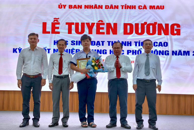 Một trong 2 thủ khoa của tỉnh Cà Mau (giữa) được tuyên dương tại buổi lễ. hs-8.jpg