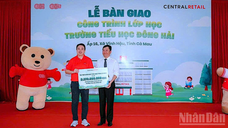 Đại diện Tập đoàn Central Retail Việt Nam (bìa trái) trao bảng tài trợ công trình xây dựng phòng học cho đại diện Ban giám hiệu Trường tiểu học Đông Hải. ndo_br_truong-hoc-4-2409.jpg