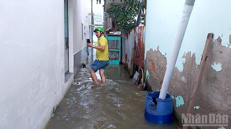 Người dân trong ngõ ở phường Bạc Liêu trở về nhà trong cảnh nước ngập sâu. ndo_br_ngap-3-2105.jpg