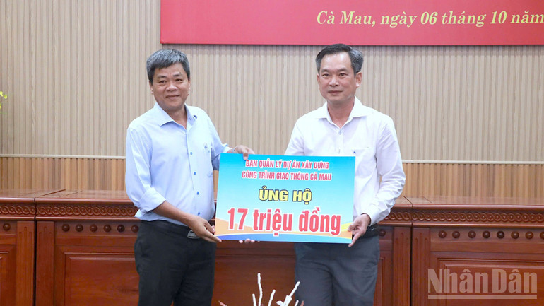 Đại diện Ban Quản lý dự án xây dựng công trình giao thông tỉnh Cà Mau trao tiền ủng hộ. ndo_br_ung-ho-4-8111.jpg