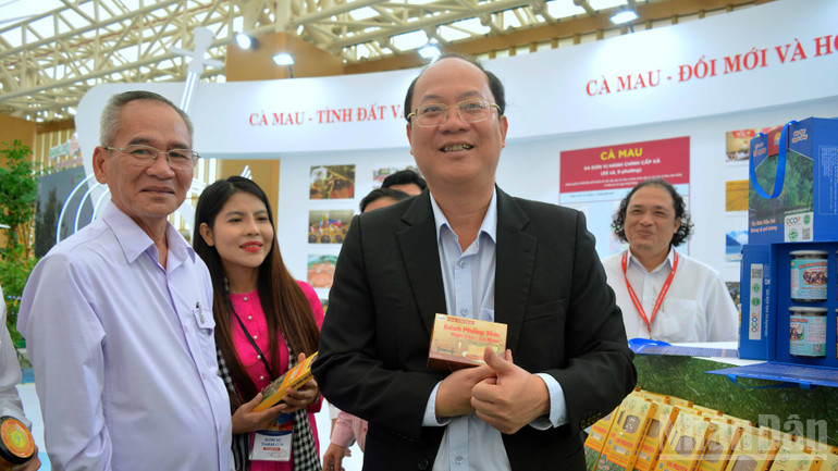 Party Central Committee member, Head of the National Assembly Delegation of Ca Mau province Lu Van Hung (left cover) and Ca Mau Provincial Party Secretary Nguyen Ho Hai (in black suit) at the OCOP specialty display area of Ca Mau province. ndo_br_trien-lam-13-838.jpg