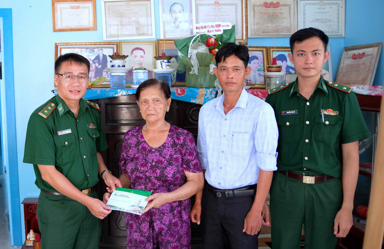 Trung tá Võ Minh Đương, Phó Chủ nhiệm Chính trị Bộ đội Biên phòng Cà Mau (bìa trái) tặng quà gia đình Anh hùng Lực lượng vũ trang nhân dân Trần Văn Tất (nguyên Đại đội trưởng Công an nhân dân tỉnh Minh Hải). bien-phong-2.jpg