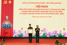 Thượng tướng Trịnh Văn Quyết trao Bằng khen của Thủ tướng Chính phủ cho Thượng úy Nguyễn Tuấn Anh, Công ty An ninh mạng Viettel. (Ảnh: ĐỨC THỌ)