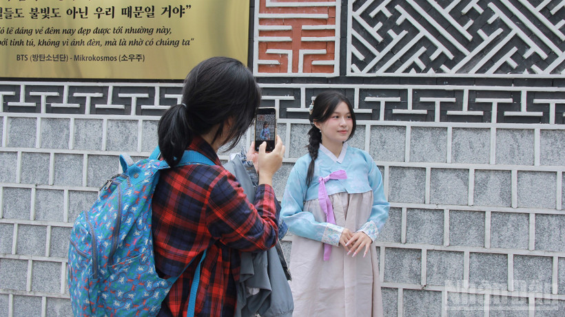 Các bạn trẻ thích thú chụp ảnh "check-in" trong trang phục Hanbok.