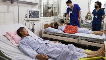 Các bác sĩ kiểm tra sức khỏe 2 bệnh nhân bị sét đánh đang điều trị tại Bệnh viện đa khoa Thanh Oai (Hà Nội).