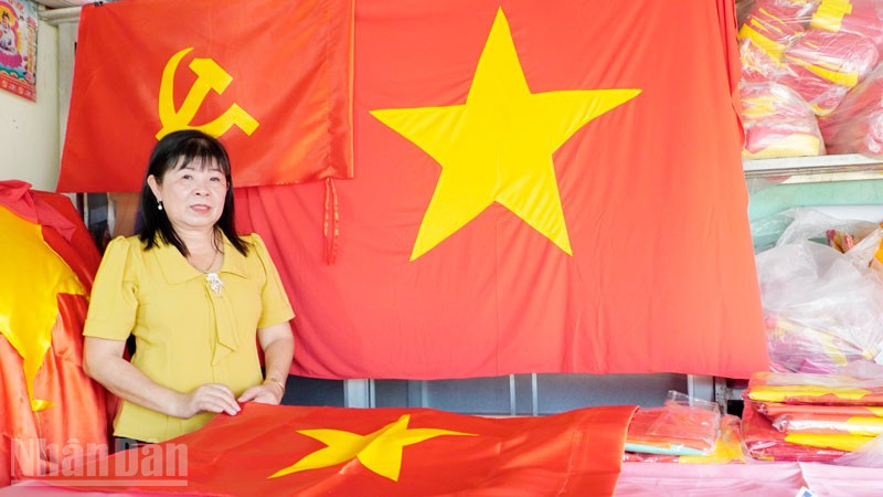 Bà Nguyễn Kiều Thu với những lá cờ Đảng, cờ Tổ quốc. 