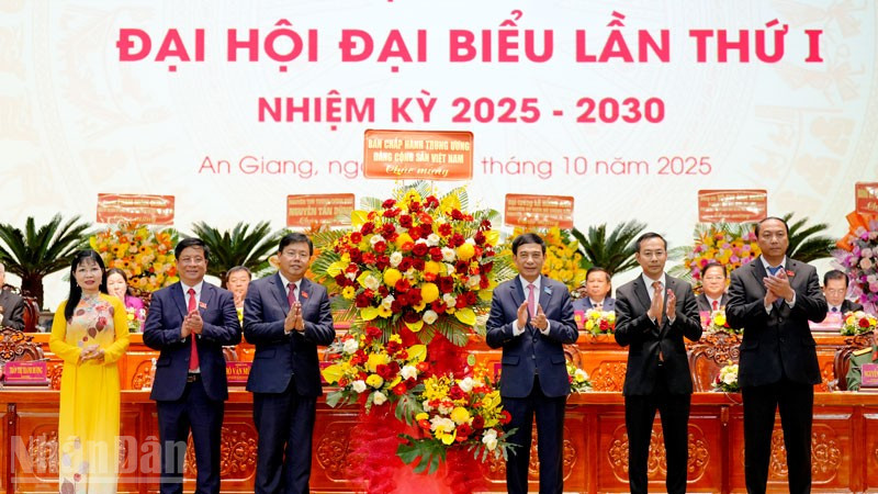 Thay mặt Bộ Chính trị, Đại tướng Phan Văn Giang tặng hoa của Ban Chấp hành Trung ương cho Đảng bộ tỉnh An Giang. (Ảnh: Ban tổ chức Đại hội cung cấp)