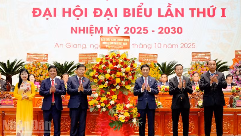 Thay mặt Bộ Chính trị, Đại tướng Phan Văn Giang tặng hoa của Ban Chấp hành Trung ương cho Đảng bộ tỉnh An Giang. (Ảnh: Ban tổ chức Đại hội cung cấp)