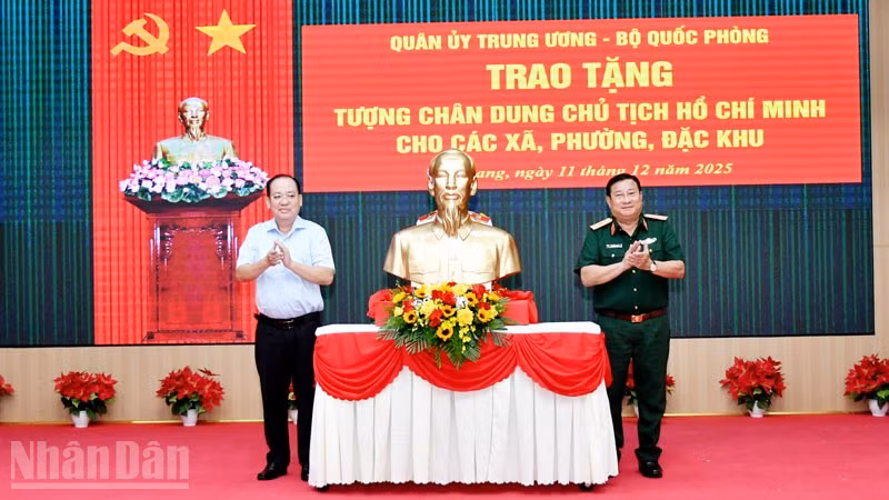 Thiếu tướng Nguyễn Văn Tiền, Phó Tư lệnh Quân khu 9 và Phó Chủ tịch Ủy ban nhân dân tỉnh An Giang Nguyễn Thanh Phong thực hiện nghi thức trao tặng tượng Bác Hồ. (Ảnh: PHƯƠNG VŨ).