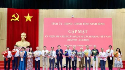 Đồng chí Đoàn Minh Huấn, Bí thư Tỉnh ủy Ninh Bình trao biểu trưng và tặng hoa chúc mừng các đồng chí lãnh đạo, nguyên lãnh đạo các cơ quan báo chí của tỉnh. (Ảnh: MINH QUANG)