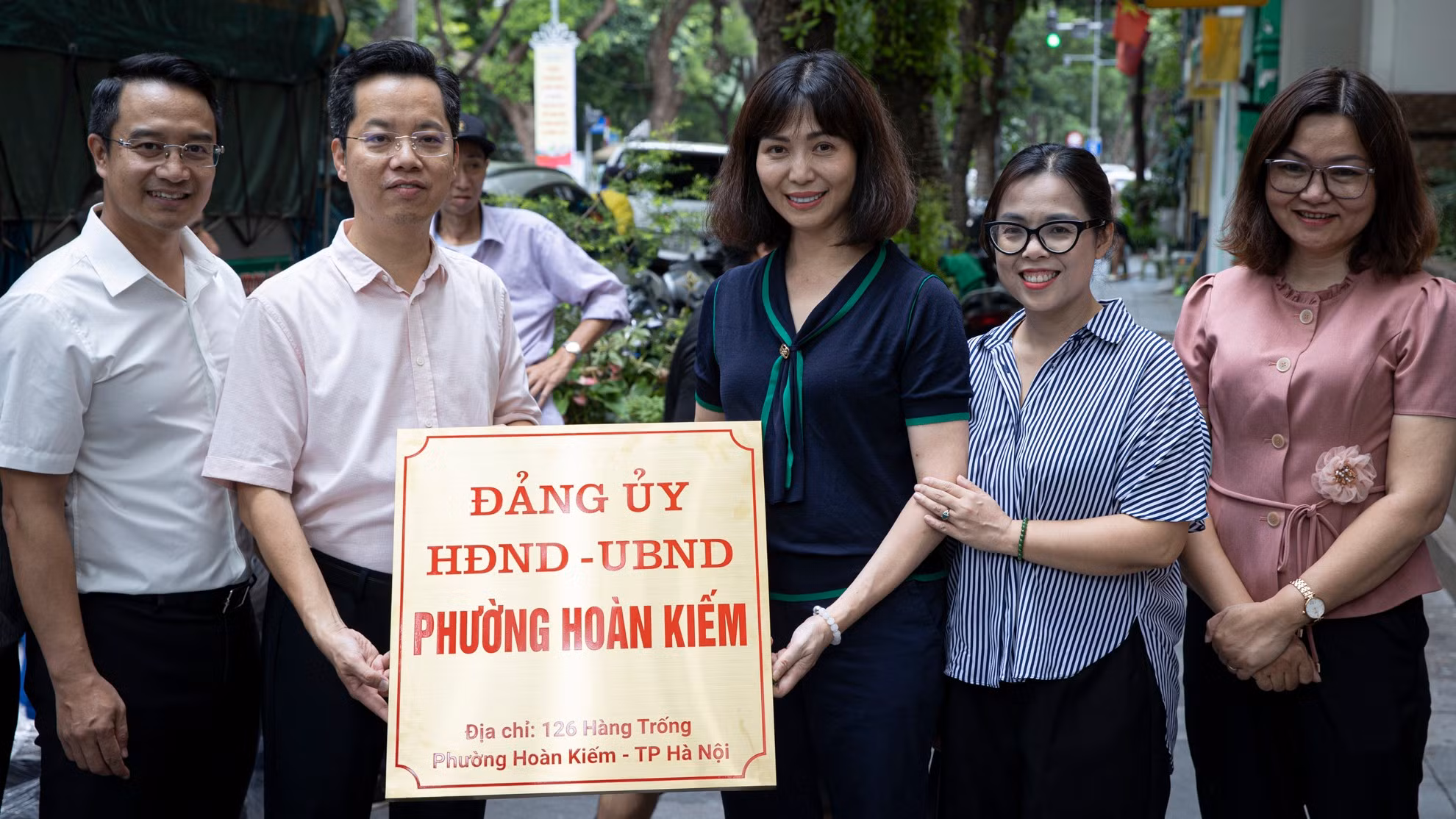 Các lãnh đạo, cán bộ chụp ảnh lưu niệm cùng biển tên mới của trụ sở Đảng ủy-Hội đồng nhân dân-Ủy ban nhân dân phường Hoàn Kiếm.