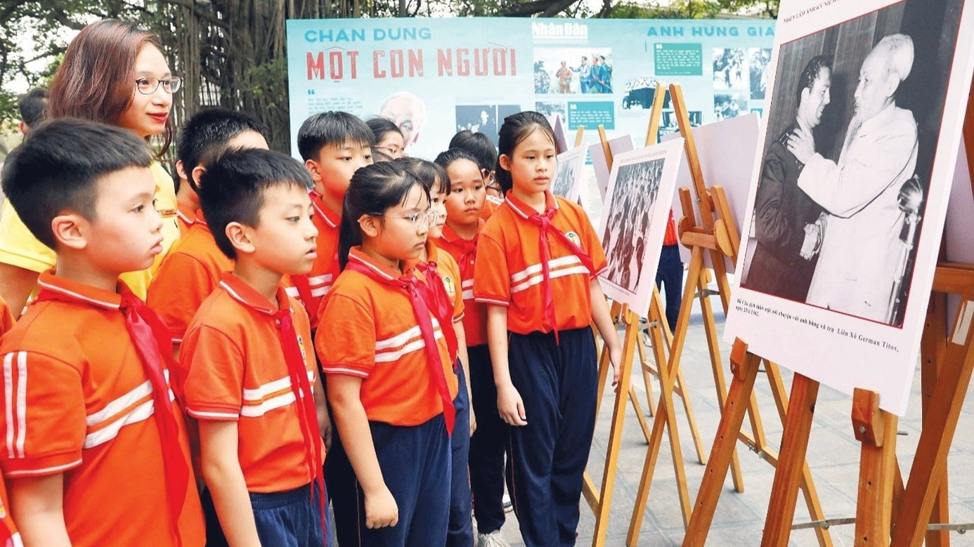 Học sinh tham quan triển lãm ảnh “Rạng rỡ tên Người” nhân dịp kỷ niệm 135 năm Ngày sinh Chủ tịch Hồ Chí Minh do Báo Nhân Dân tổ chức. (Ảnh: KHIẾU MINH)
