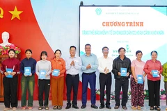 Các đại biểu trao tặng thẻ bảo hiểm y tế cho người dân có hoàn cảnh khó khăn. (Ảnh: BTC)