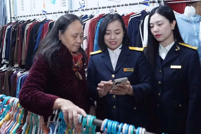 Cán bộ Thuế thành phố Hà Nội hướng dẫn hộ kinh doanh thực hiện thủ tục kê khai thuế.