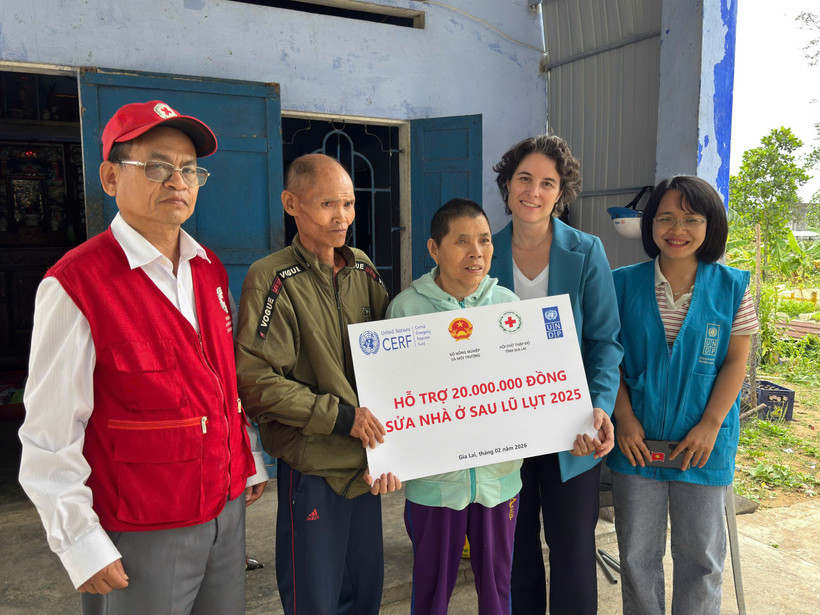 Đại diện Chương trình Phát triển Liên hợp quốc (UNDP) trao tiền hỗ trợ cho gia đình bị ảnh hưởng bởi bão lũ.