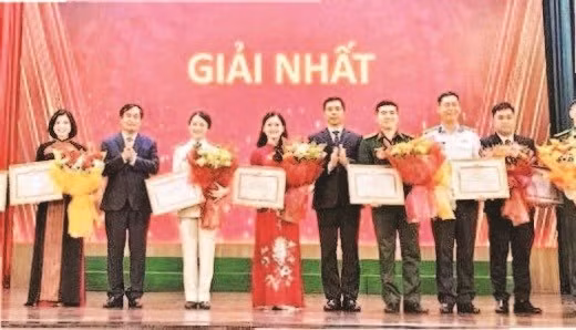 Lãnh đạo Ban Tuyên giáo Trung ương và Thường trực Tỉnh ủy Thanh Hóa trao chứng nhận, tặng hoa chúc mừng các báo cáo viên, tuyên truyền viên đoạt giải nhất (Ảnh MAI LUẬN)