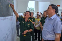 Chủ tịch Ủy ban nhân dân tỉnh Cà Mau Phạm Thành Ngại (áo sơ mi) nghe Ban điều hành Trường sơn 12 thông tin về tiến độ giải phóng mặt bằng dự án.