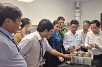 Phó Giám đốc Sở Y tế Tây Ninh Mai Văn Dũng (bìa phải), Trưởng đoàn số 1 của tỉnh kiểm tra, hậu kiểm việc lưu giữ mẫu thực phẩm tại Nhà hàng Buffet Vân Sơn.