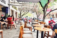 Các quán cà-phê trên đường Vũ Huy Tấn, phường Gia Định lấy luôn vỉa hè để buôn bán, đẩy người đi bộ xuống lòng đường.