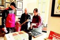 Võ Ca Dao hướng dẫn cho du khách nước ngoài trải nghiệm in tranh mộc bản.