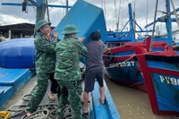 Cán bộ, chiến sĩ Đồn Biên phòng Xuân Hòa, Ban Chỉ huy Bộ đội Biên phòng tỉnh Đắk Lắk hỗ trợ ngư dân đưa phương tiện đánh bắt cá lên bờ, bảo đảm an toàn trước khi bão số 13 đổ bộ.