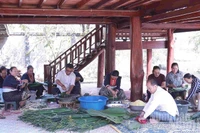 Gia đình Thượng tướng Souvon Leuangbounmi quây quần gói bánh chưng ngày Tết. (Ảnh: Duy Toàn)