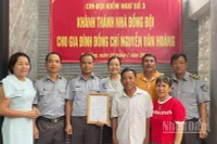 Đồng chí Vũ Văn Tài, Bí thư Đảng ủy Chi đội Kiểm ngư số 3 (thứ hai từ trái sang) trao kinh phí hỗ trợ nhà đồng đội cho gia đình đồng chí Nguyễn Văn Hoàng. (Ảnh: TIẾN DŨNG)