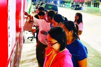 Công nhân Công ty TNHH Pouyuen Việt Nam tìm hiểu tiểu sử của các ứng cử viên được niêm yết tại khu vực nhà máy.