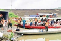 Các lực lượng chức năng xã Trà Đốc xếp lương thực, nhu yếu phẩm lên thuyền để vượt sông Tranh vào tiếp tế cho người dân bị cô lập.