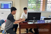 Cán bộ Trung tâm Phục vụ hành chính công xã Mỹ Lợi hướng dẫn người dân thao tác nộp hồ sơ trực tuyến. 