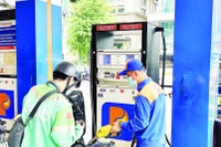 Người dân mua xăng sinh học E10 tại một điểm bán xăng dầu ở phường Xuân Hòa. (Ảnh HOÀNG LIÊM)