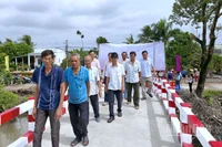 Người dân vùng quê ấp Lung Chim, xã Định Thành vui mừng đi qua cầu mới hoàn thành. 