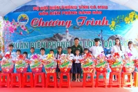 Đại tá Phạm Minh Giang, Chính ủy Bộ đội Biên phòng Cà Mau (đứng giữa) trao quà tặng học sinh nghèo vùng ven biển Gành Hào.