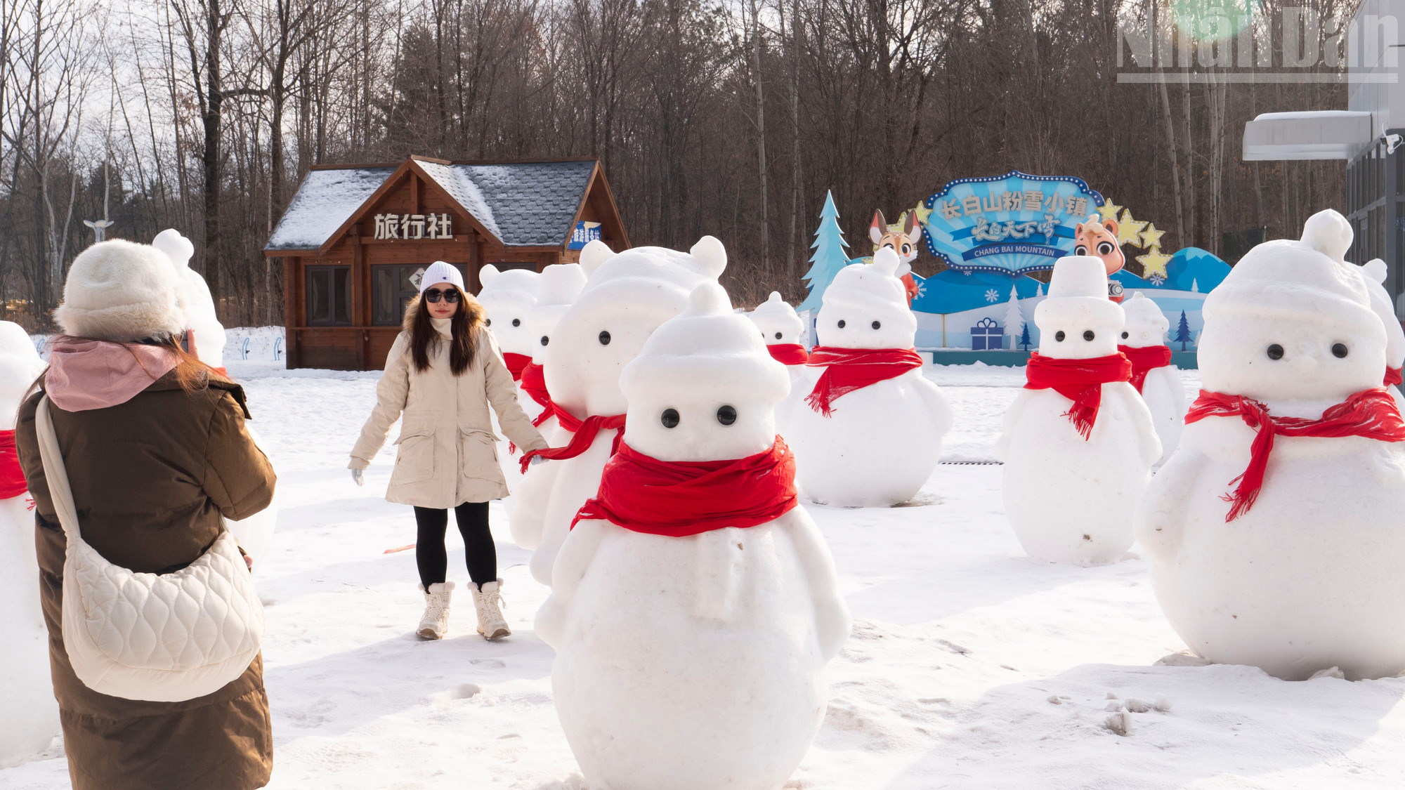 Du khách chụp ảnh check-in với người tuyết bên ngoài ga tàu cao tốc Trường Bạch Sơn.