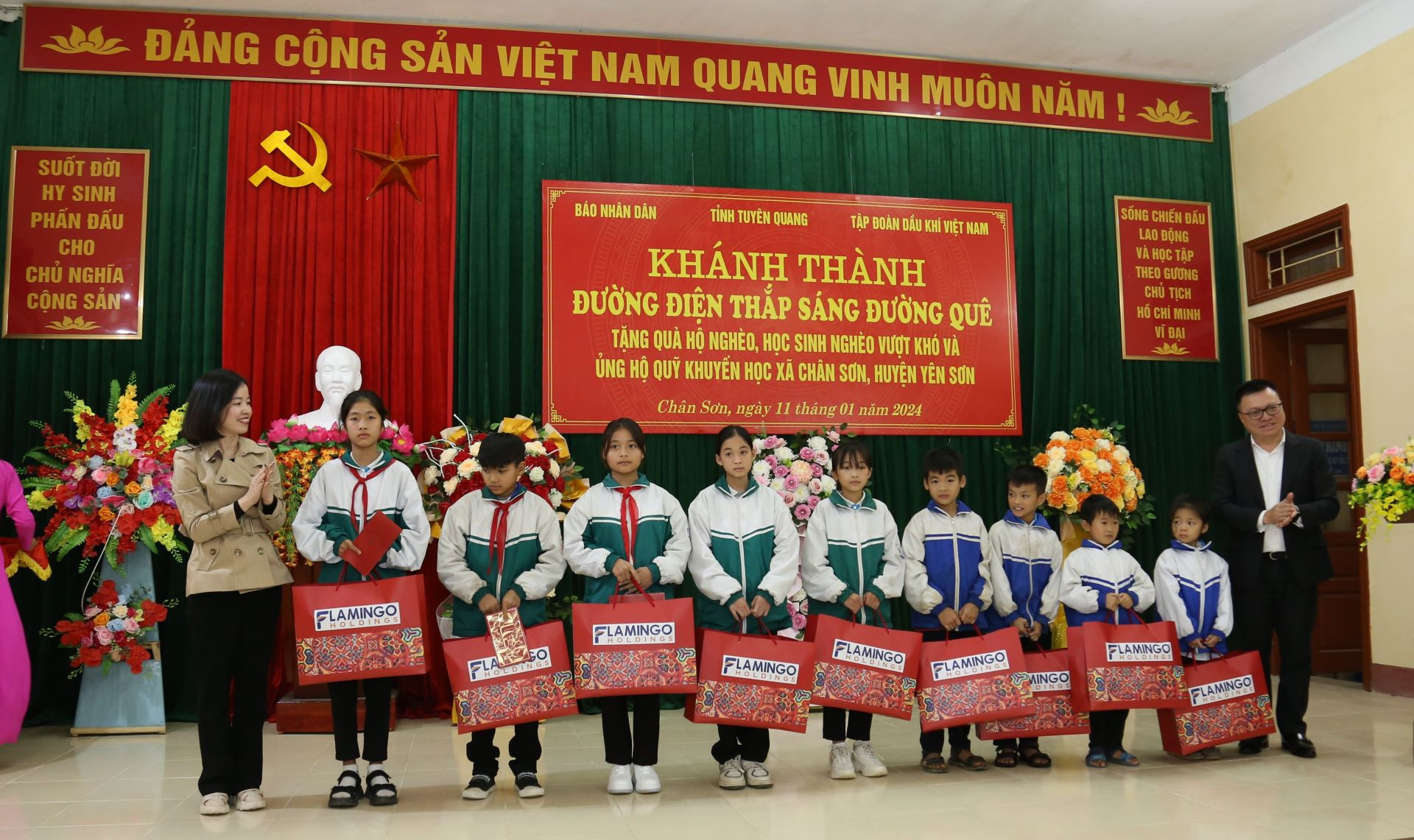 Lãnh đạo Báo Nhân Dân và đại diện Tập đoàn Flamingo trao quà cho các em học sinh nghèo vượt khó.