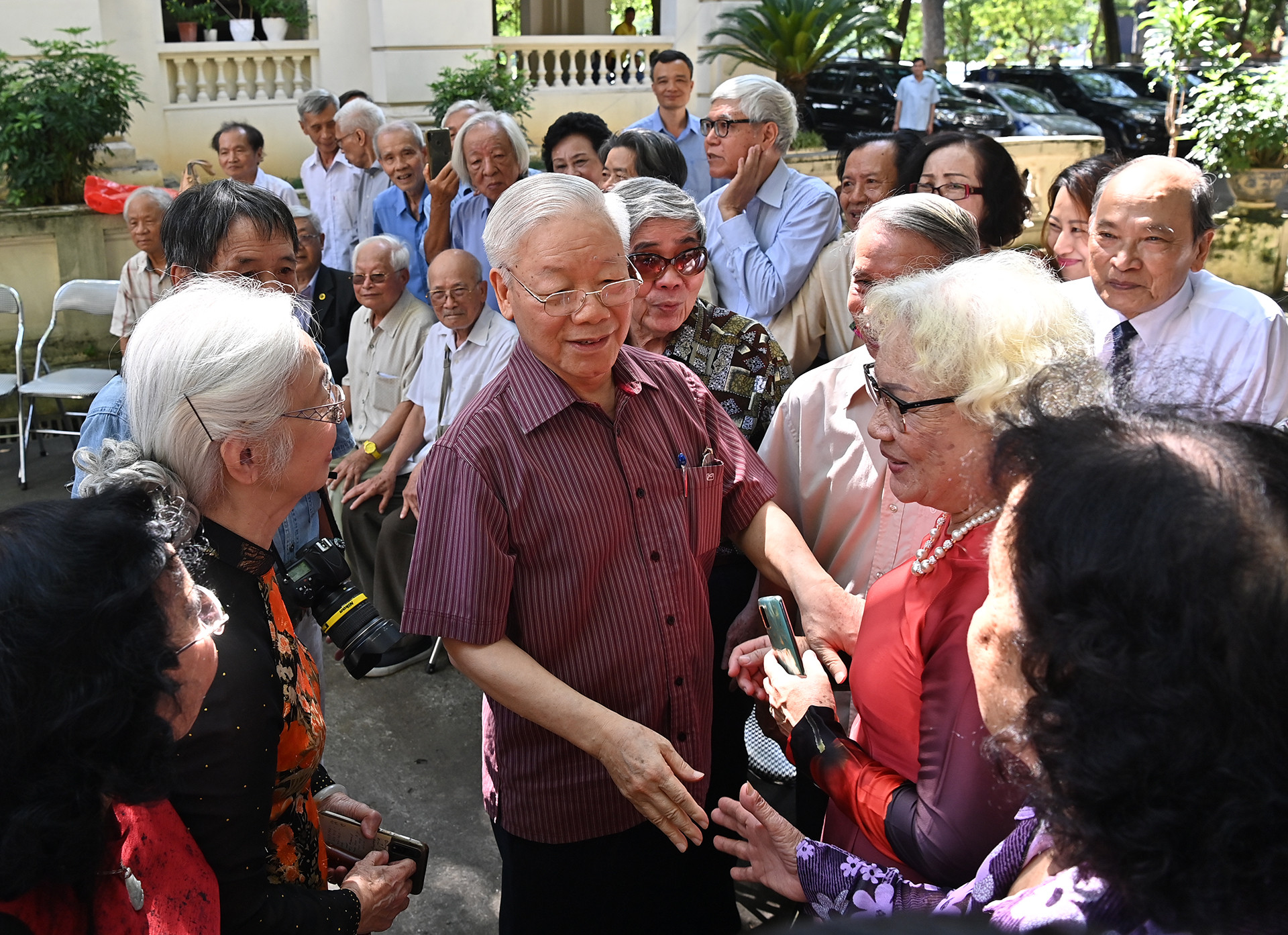 Các thành viên lớp Văn khóa VIII đã về tụ họp rất đông, trò chuyện dưới gốc đa trong khuôn viên báo.