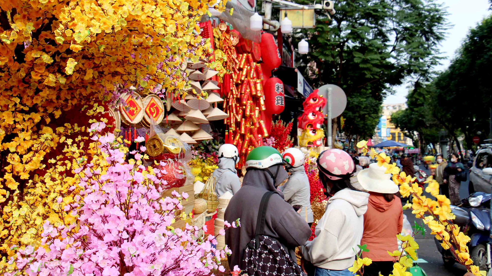 Con đường dài khoảng 500m, hai bên các cửa hàng bắt đầu bày bán các loại đồ trang trí Tết như: câu đối đỏ, hoa đào, mai giả, phong bì, lồng đèn, lịch...