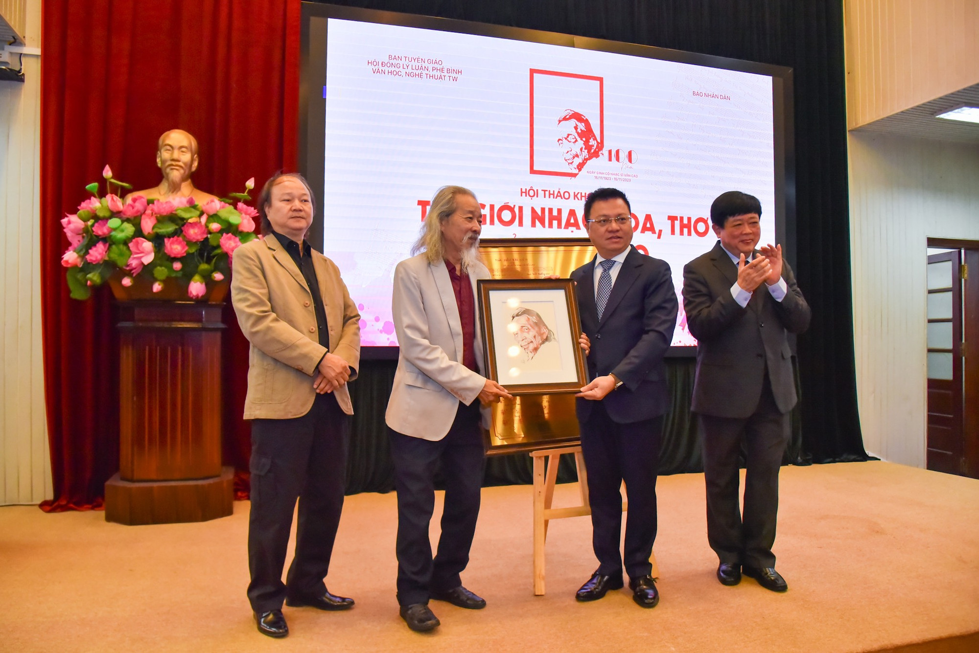 Đồng chí Lê Quốc Minh, Ủy viên Trung ương Đảng, Tổng Biên tập Báo Nhân Dân, Phó Trưởng Ban Tuyên giáo Trung ương, Chủ tịch Hội Nhà báo Việt Nam và Phó Giáo sư, Tiến sĩ, nhà văn Nguyễn Thế Kỷ trao món quà đặc biệt kính tặng đại diện gia đình nhạc sĩ Văn Cao.