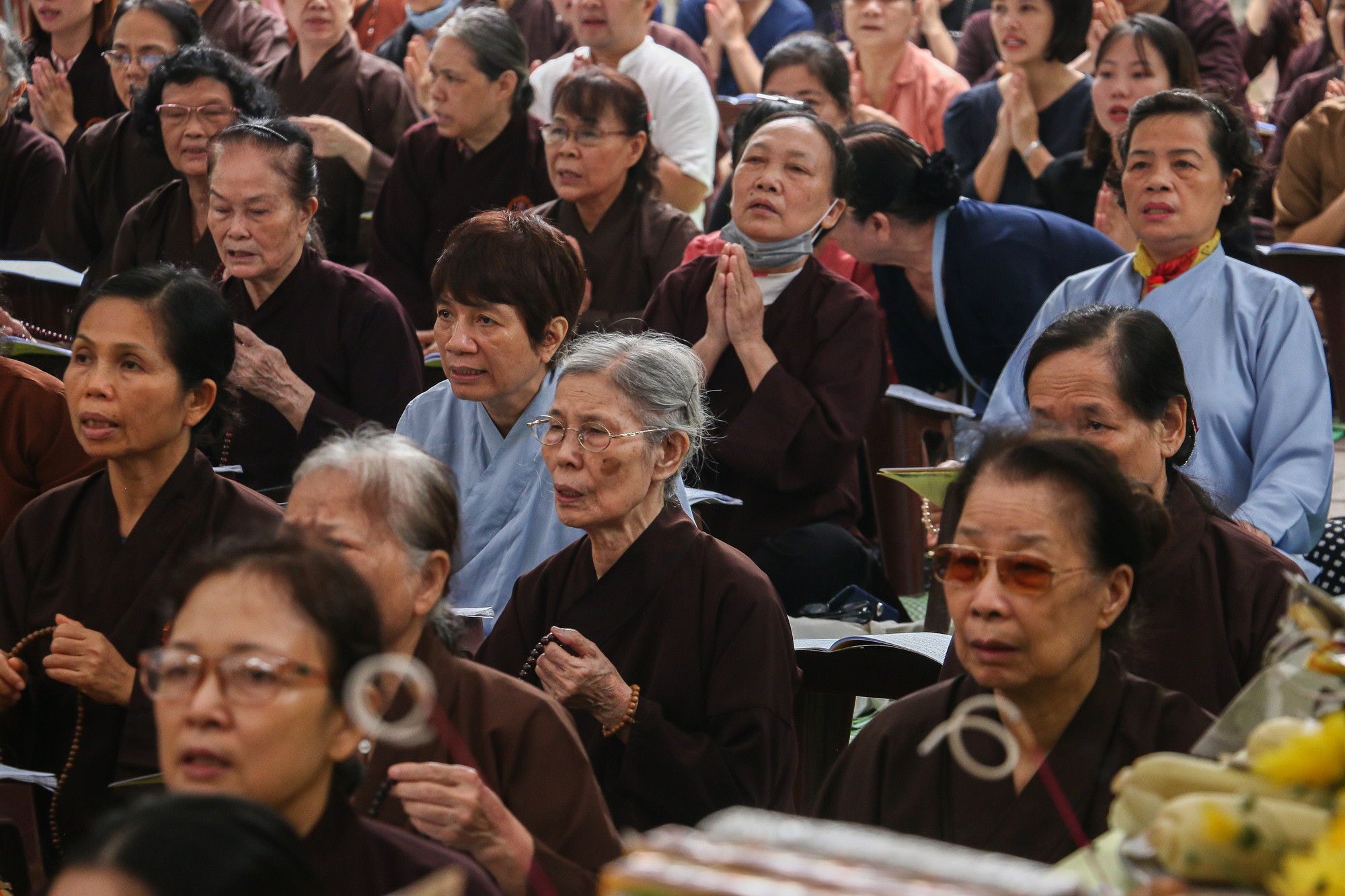 Hơn trăm phật tử ngồi đọc kinh, cầu nguyện cho những người đã khuất được siêu thoát.