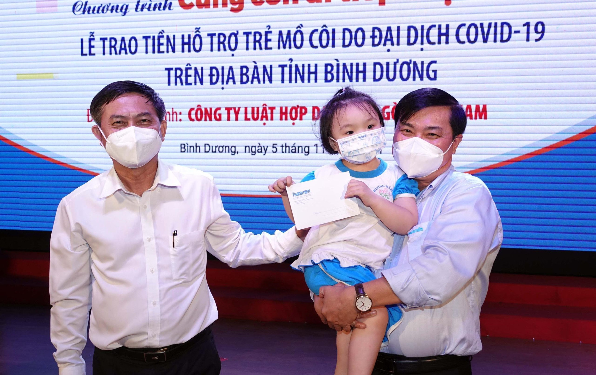 Anh Nguyễn Ngọc Toàn - Tổng Biên tập Báo Thanh Niên (bên phải) và ông Nguyễn Văn Lộc - Trưởng ban Dân vận Tỉnh ủy Bình Dương, bên trẻ mồ côi.