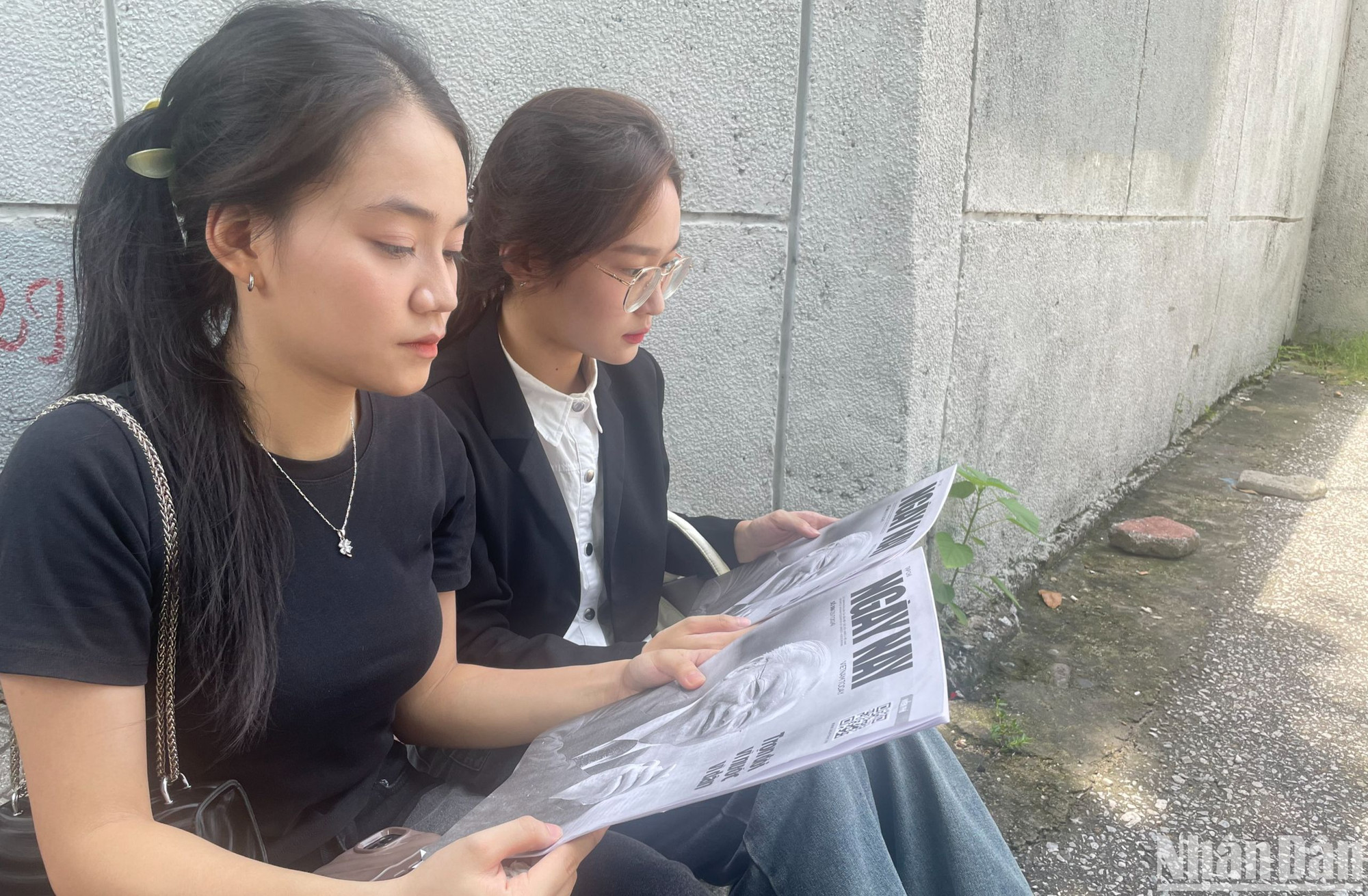 Thiên Hương và Nhật Mỹ chăm chú đọc ấn phẩm đặc biệt số 386 của tạp chí Ngày Nay để hiểu rõ hơn về Tổng Bí thư Nguyễn Phú Trọng.