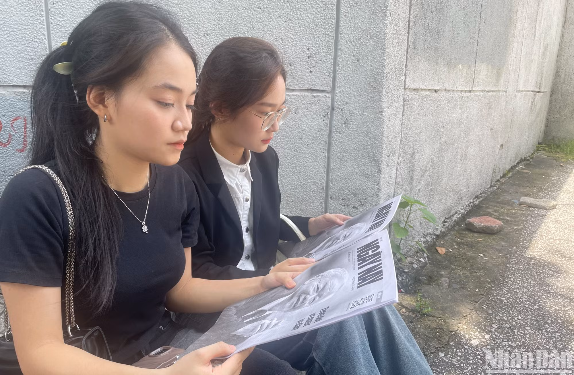 Thiên Hương và Nhật Mỹ chăm chú đọc ấn phẩm đặc biệt số 386 của tạp chí Ngày Nay để hiểu rõ hơn về Tổng Bí thư Nguyễn Phú Trọng.