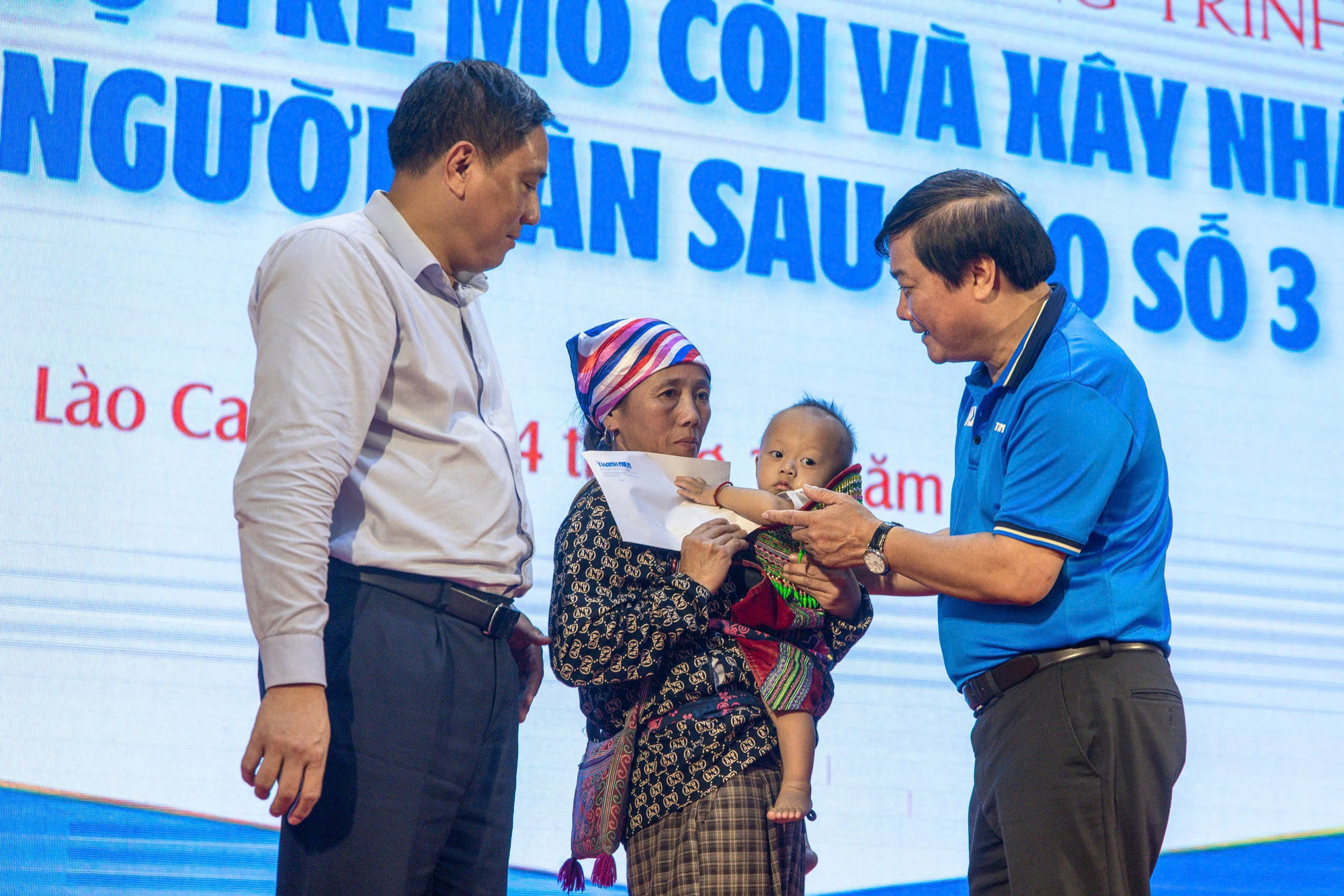 Ông Hoàng Giang, Phó Bí thư Tỉnh ủy Lào Cai, cùng nhà báo Nguyễn Ngọc Toàn, Tổng Biên tập Báo Thanh Niên, trao số tiền bảo trợ 3 tháng đầu tiên cho các em nhỏ mồ côi.