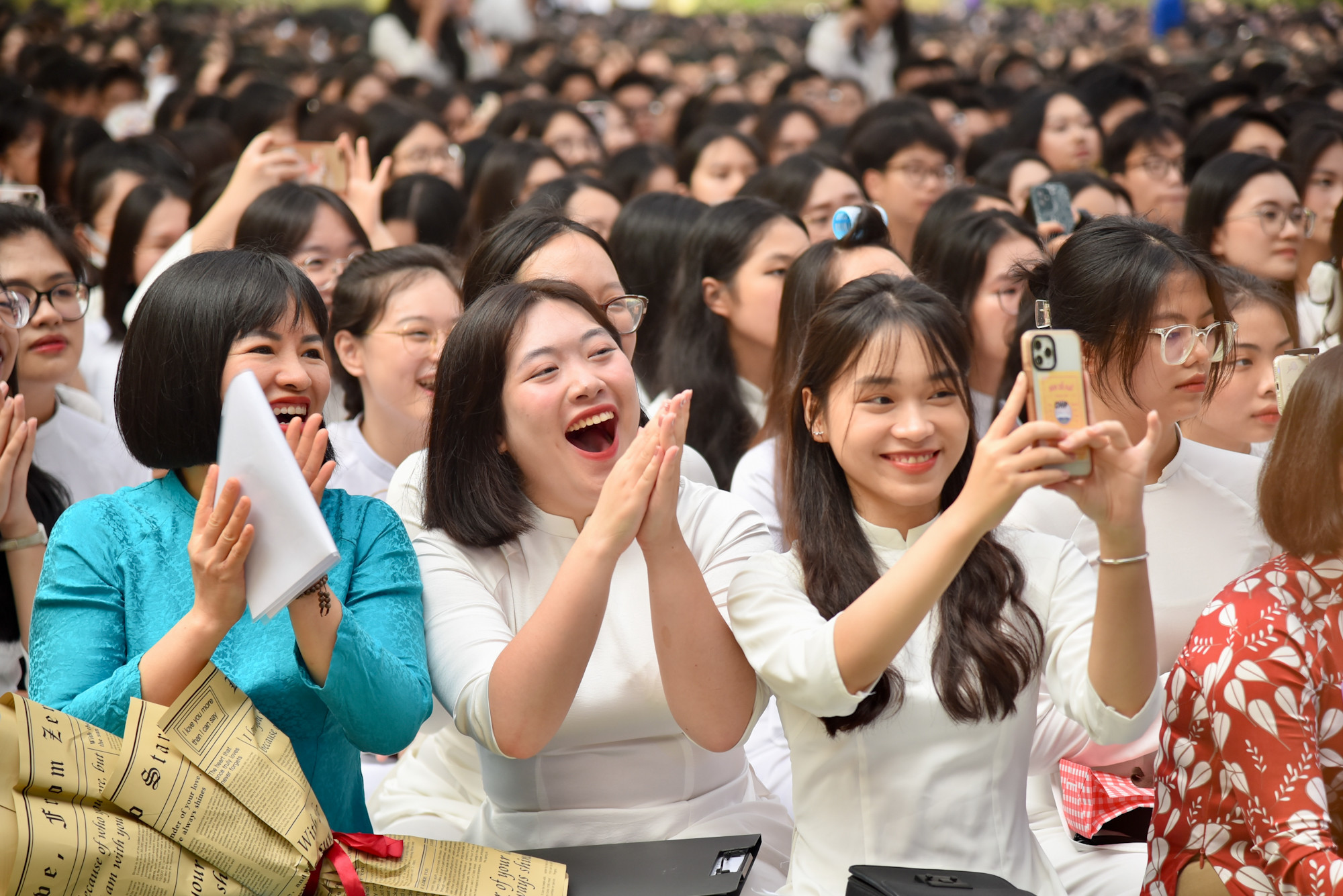 Tiết trời Hà Nội dù oi bức, nắng nóng, thầy cô và học trò vẫn ngồi dưới sân trường, chăm chú lắng nghe từng bài phát biểu trên sân khấu.