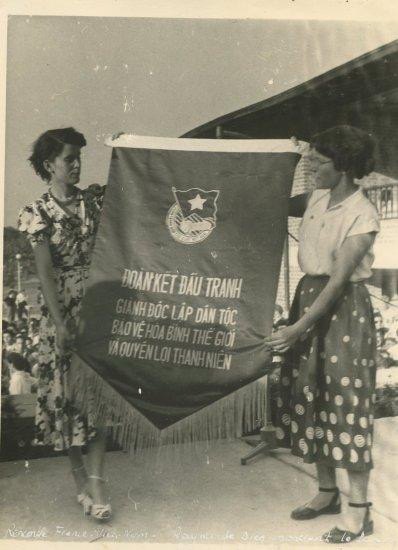 Raymonde Dien (trái) tại Đại hội Thanh niên ở Bucharest, Romania, năm 1953. Trong tay bà đang cầm khẩu hiệu của phái đoàn Việt Nam tham dự hội nghị trao tặng. (Ảnh: Robert Aimé)