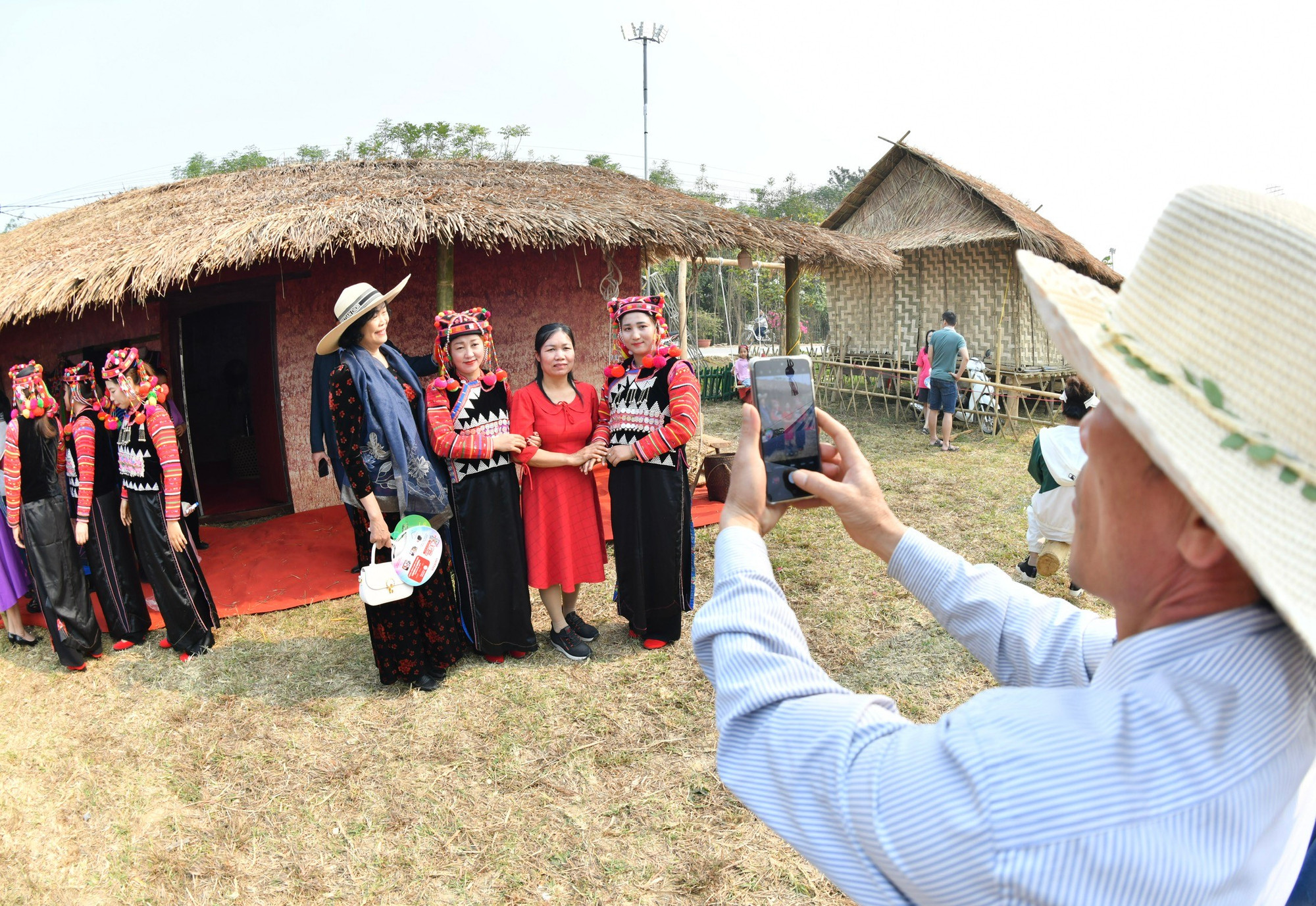 Du khách hào hứng chụp ảnh cùng phụ nữ dân tộc Hà Nhì.