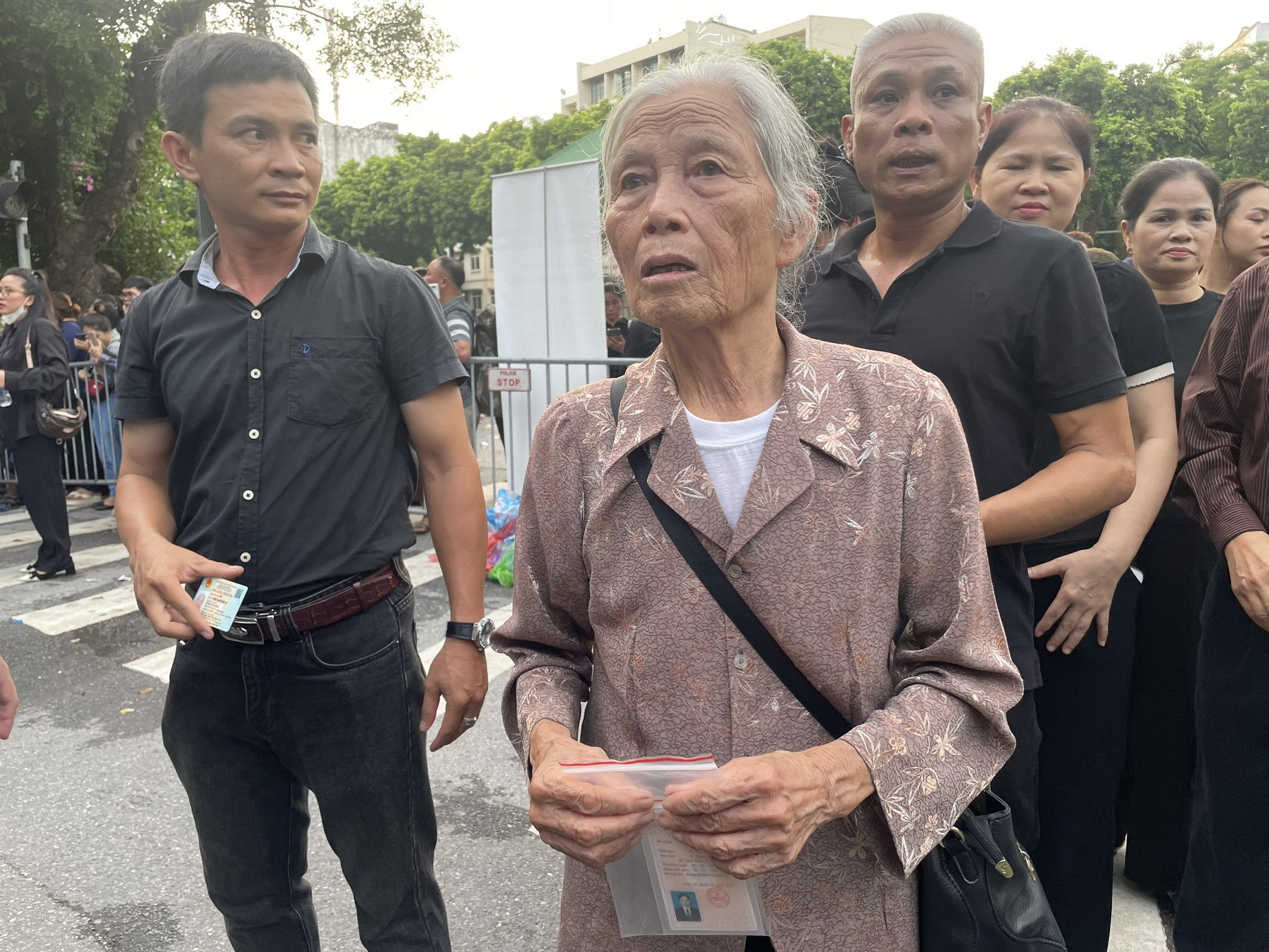 Bà Hoàng Thị Mến cầm trên tay tấm thẻ đảng viên vào viếng Tổng Bí thư.